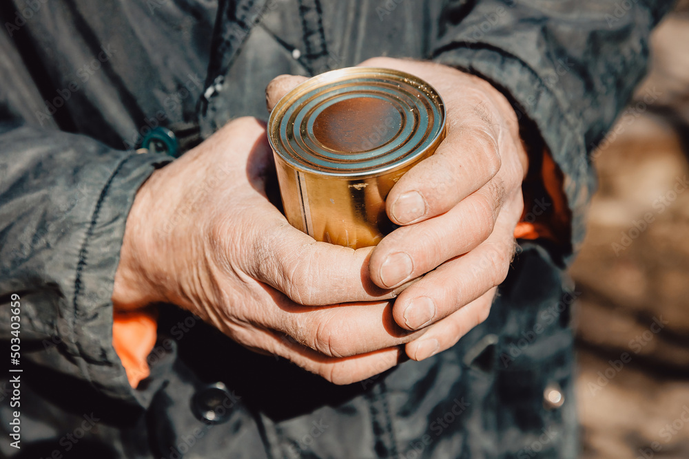 Concept global crisis, economic recession. Dirty hands homeless old poor man with canned food donation Concept global crisis, economic recession. Dirty hands homeless old poor man with canned food donation