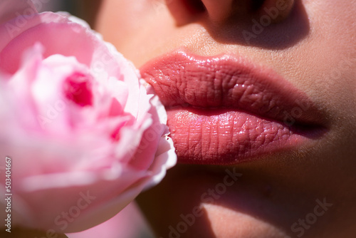 Lips with lipstick closeup. Beautiful woman lips with rose. Close up, macro with beautiful mouths.