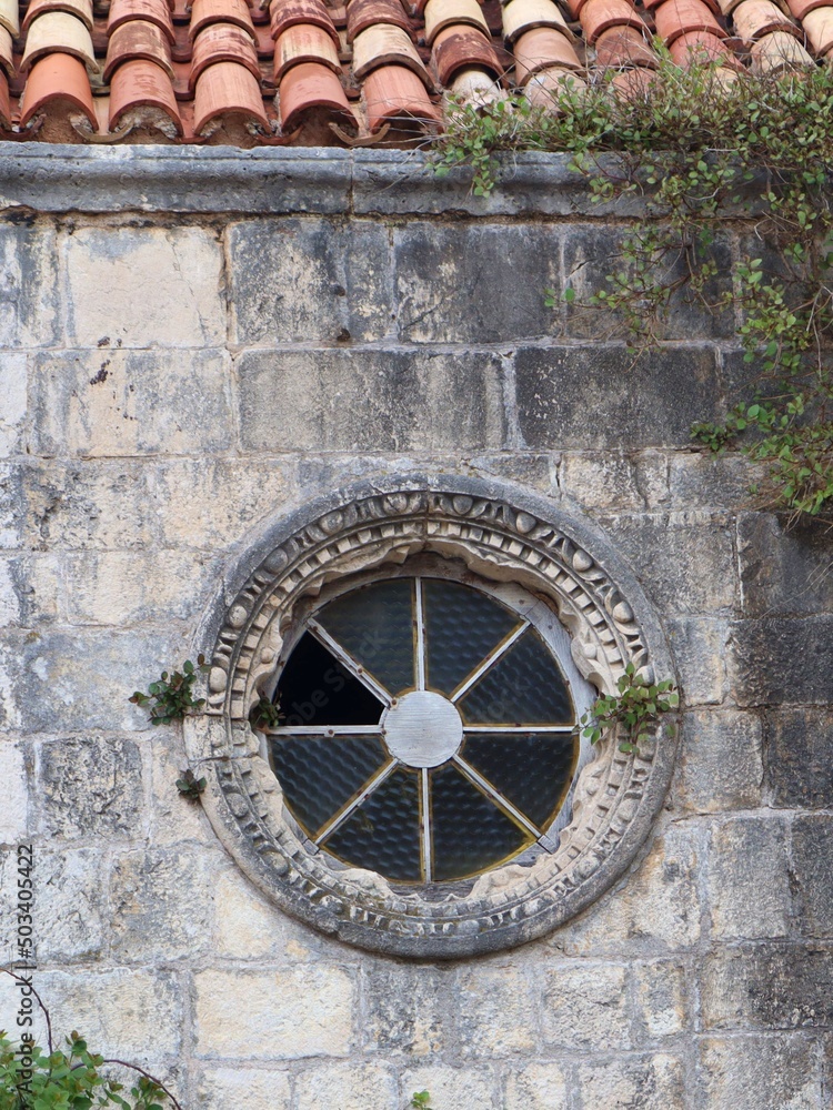 Piękne stare okrągłe okno w murze na Starówce