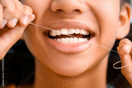 African-American teenage girl flossing teeth, closeup