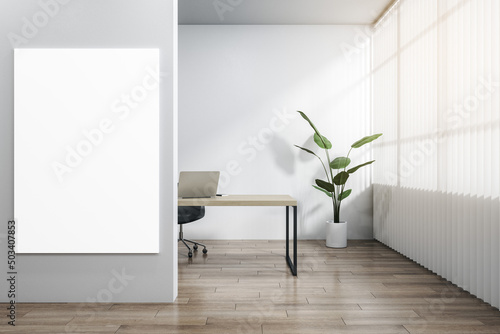 Modern wooden and concrete office interior with blank white mock up poster  workplace desk  laptop  chair  decorative plant  blinds and daylight. 3D Rendering.