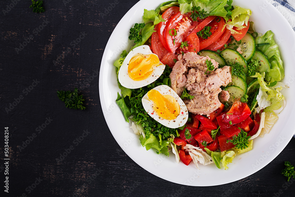 Tuna fish salad with lettuce, tomatoes, cucumber, boiled egg and sweet pepper. Healthy food. French cuisine. Top view, copy space, flat lay Tuna fish salad with lettuce, tomatoes, cucumber, boiled egg and sweet pepper. Healthy food. French cuisine. Top view, copy space, flat lay