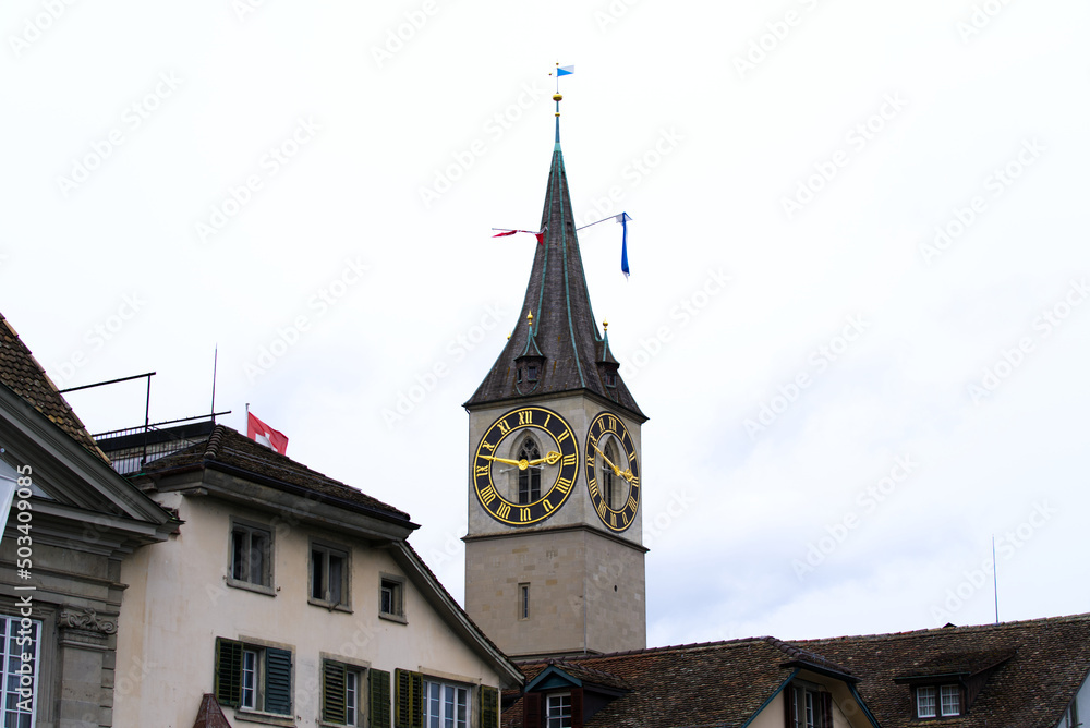 Clock tower of protestant church St. Peter with largest church clock face at the old town of Zürich on a rainy spring day, focus on background. Photo taken April 24th, 2022, Zurich, Switzerland. Clock tower of protestant church St. Peter with largest church clock face at the old town of Zürich on a rainy spring day, focus on background. Photo taken April 24th, 2022, Zurich, Switzerland.