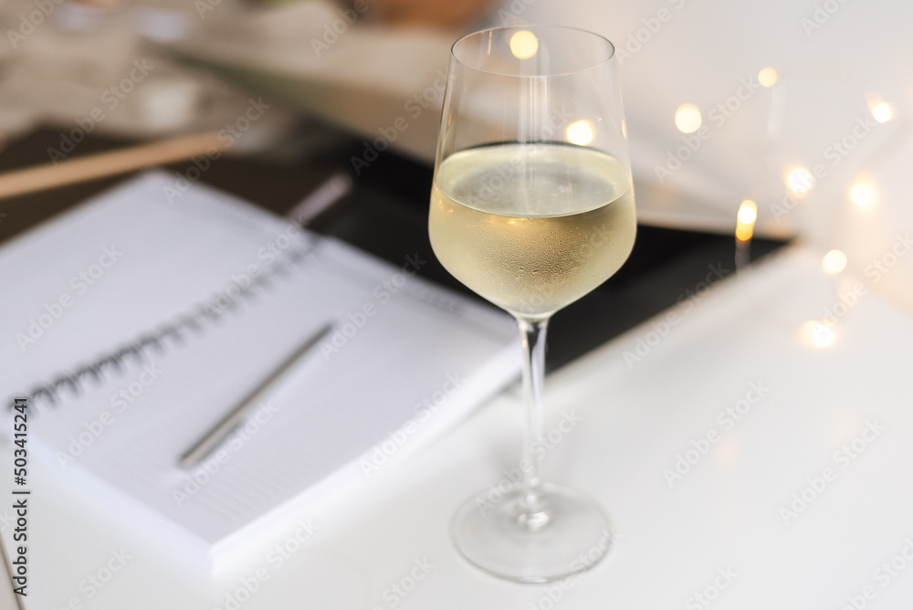 A glass of white wine on the desk. A glass of white wine on the desk.