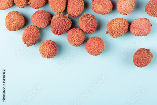 Lychee on a blue background, flat lay, empty space for text