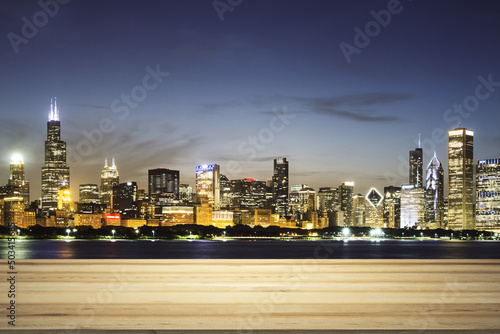 Empty wooden table top with beautiful Chicago skyscrapers at evening on background  mock up