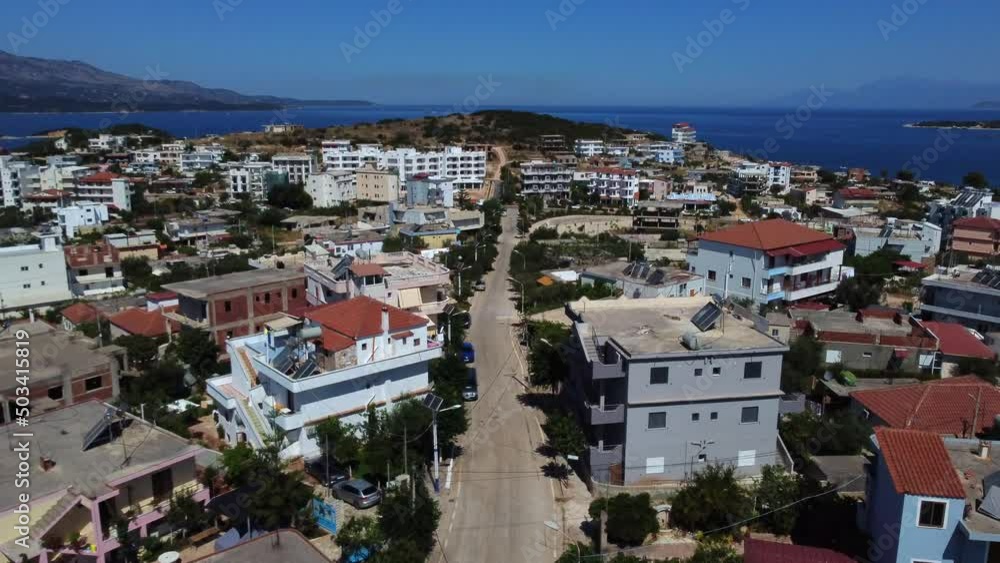 Drone shot of Ksamil, Albania - drone is following a street in the fishermen village and revealing the ocean in the back. Snippet could ideally be used for travel related videos or movies. Drone shot of Ksamil, Albania - drone is following a street in the fishermen village and revealing the ocean in the back. Snippet could ideally be used for travel related videos or movies.