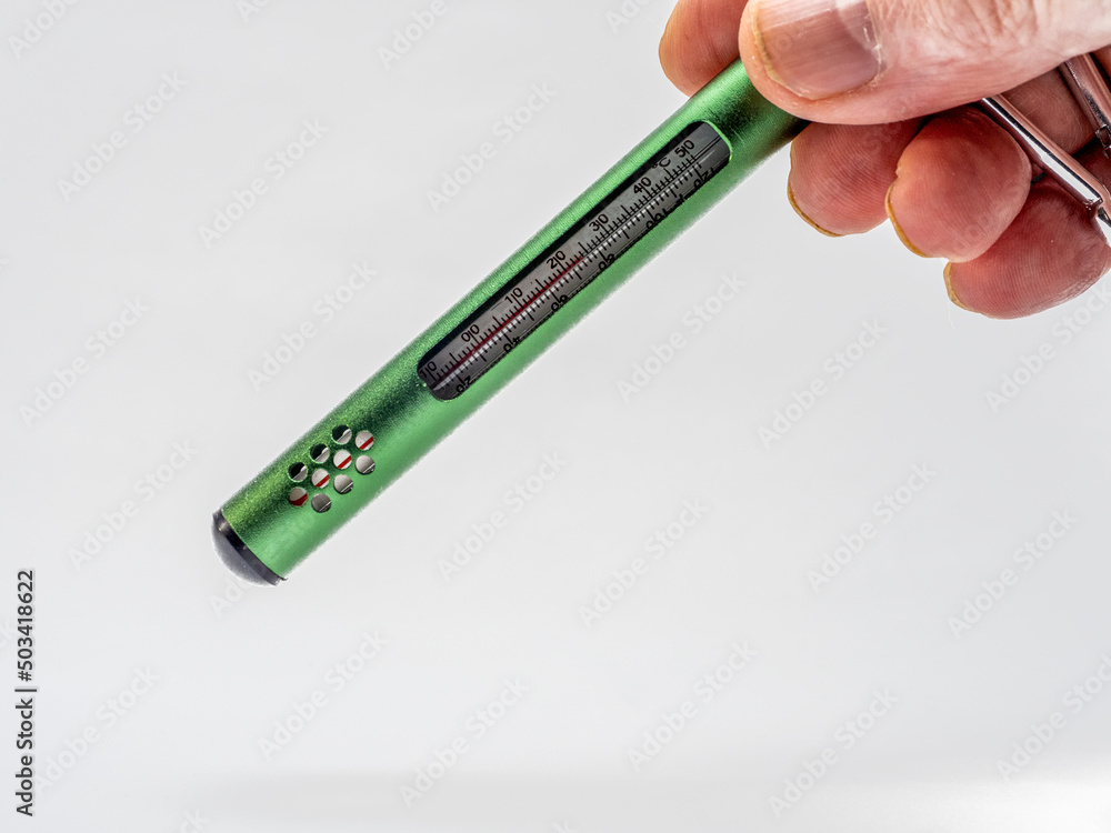 Obraz premium person testing the room temperature with a hand held mercury thermometer