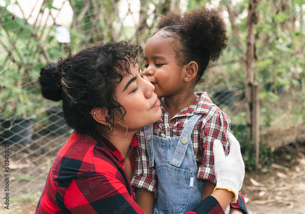 Happy kid girl kiss mom between work of farming Happy kid girl kiss mom between work of farming
