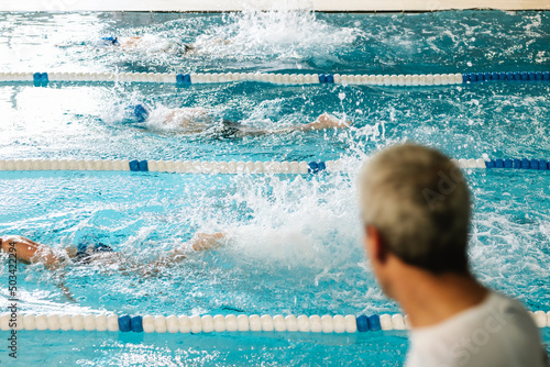 unrecognizable swimming coach coaching his students
