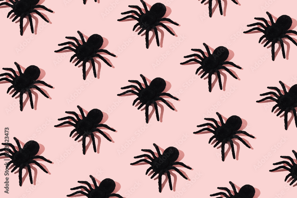 Black spider pattern on pink background. Minimal Halloween concept. Black spider pattern on pink background. Minimal Halloween concept.