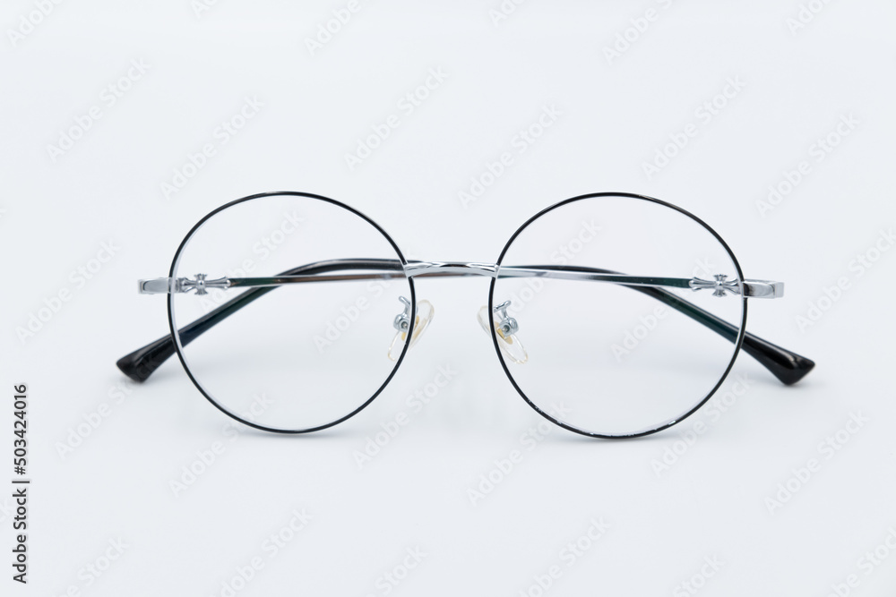 Selective focus round eyeglasses with silver rim. Isolated white background. Selective focus round eyeglasses with silver rim. Isolated white background.