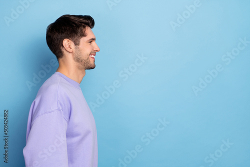 Profile side view portrait of attractive cheerful guy copy blank space ad isolated over bright blue color background