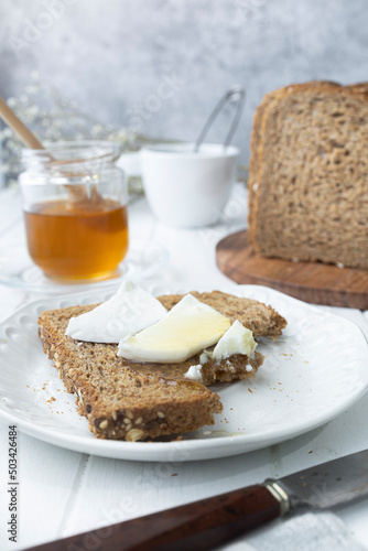 Healthy breakfast with wholemeal bread, fresh goat cheese and raw honey. A delicious breakfast.