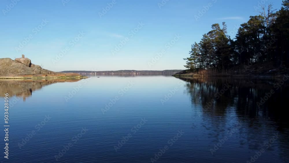 Bay in early morning sunlight in Sweden, ripples on water from drone Bay in early morning sunlight in Sweden, ripples on water from drone