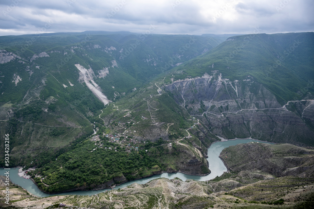 deep gorge with a river flowing below on a spring sunny day in Dagestan