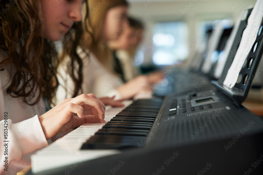 Foto de Teenage girl attending keyboard lesson do Stock | Adobe Stock