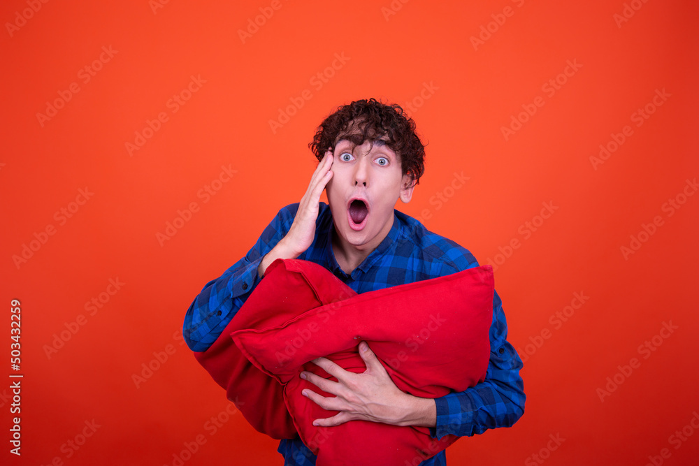 Young attractive guy with red pillows. Young attractive guy with red pillows.