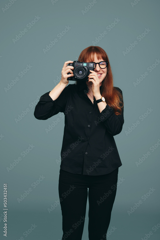 Smiling photographer taking a picture on her digital camera Smiling photographer taking a picture on her digital camera