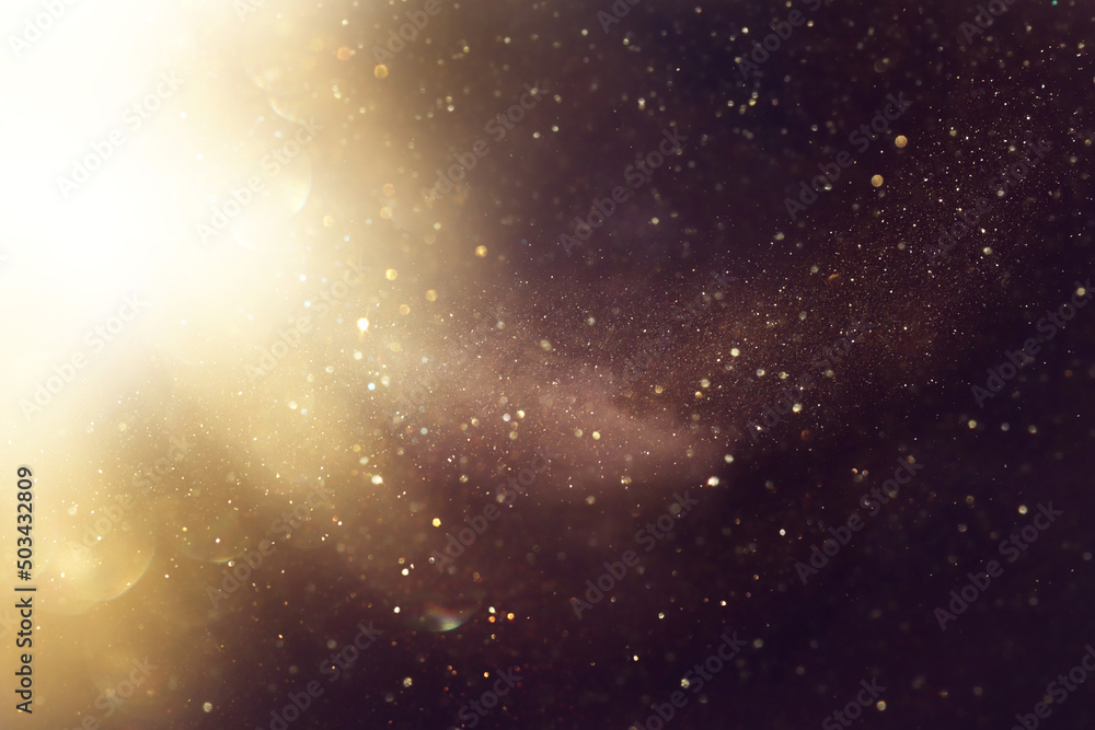 Naklejka premium background of abstract glitter lights. gold and black. de focused