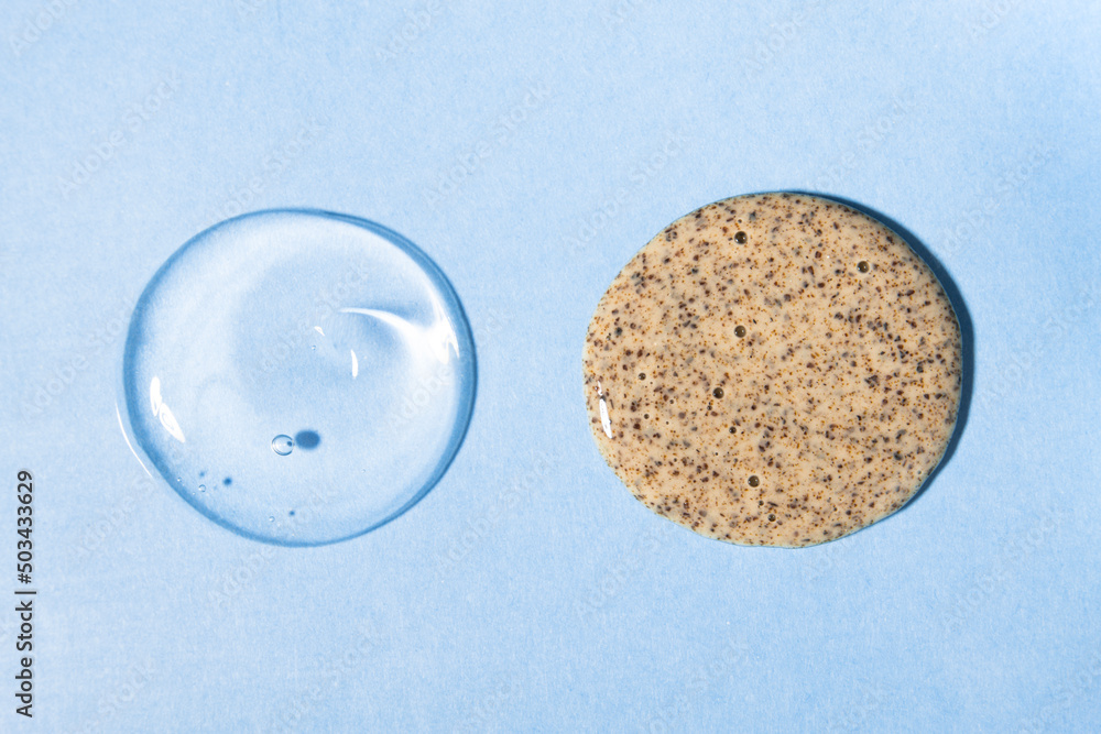 Samples of body scrub and transparent hyaluronic gel on a blue background. Cosmetic texture close-up, top view. Samples of body scrub and transparent hyaluronic gel on a blue background. Cosmetic texture close-up, top view.