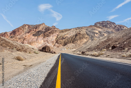 beautiful landscape of a road through death valley usa with a cloud appearing to point the direction