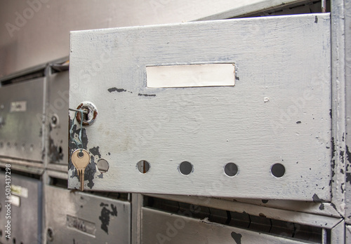 old open silver mailbox on the wall.