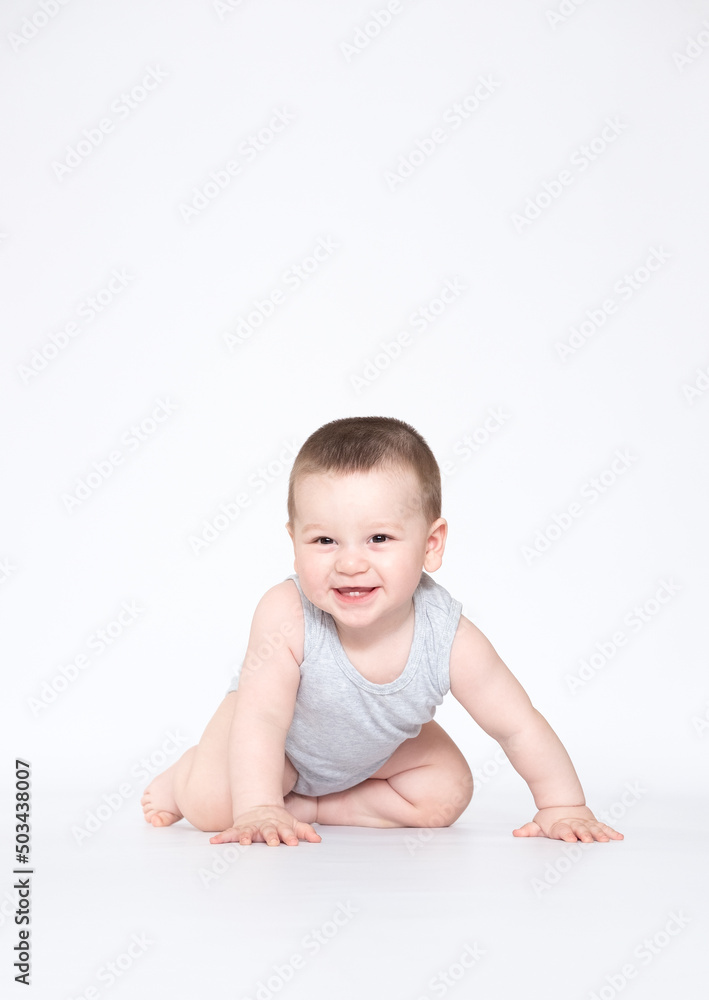 eight month old baby boy crowling on the ground and looking at camera eight month old baby boy crowling on the ground and looking at camera