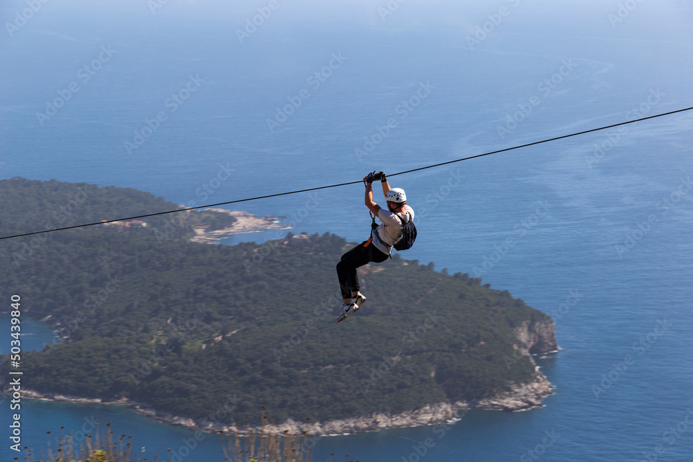 Man going down on rope above Adriatic sea. Adventure attraction near Dubrovnik. Croatia. Man going down on rope above Adriatic sea. Adventure attraction near Dubrovnik. Croatia.