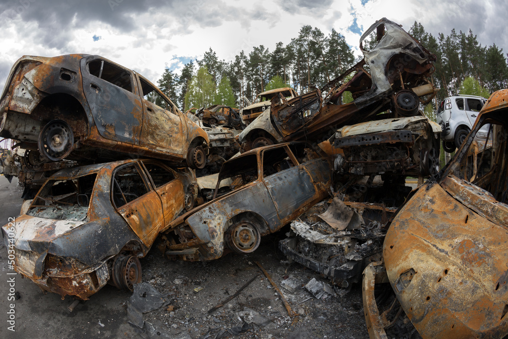 Burned civilian car. Stacked vehicles. War in Ukraine. 