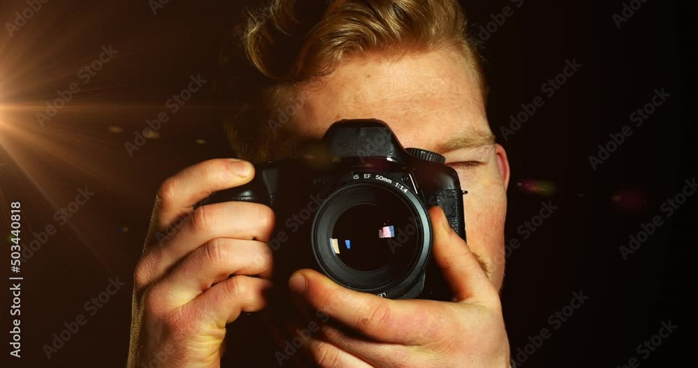 Animation of light over caucasian male photographer with camera on black background Animation of light over caucasian male photographer with camera on black background