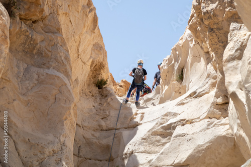 An experienced athlete athlete descends with the equipment for snapping in the mountains of the Judean Desert near the Tamarim stream near Jerusalem in Israel photo