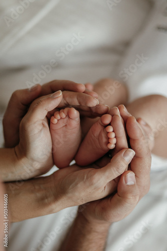 newborn baby feet on mom and dad hands. happy family concept