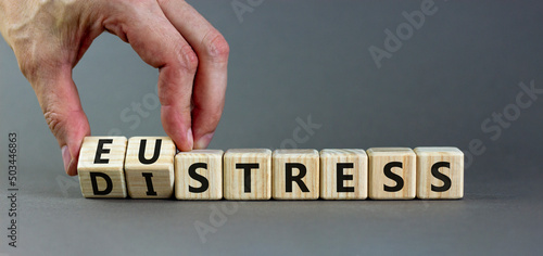 Eustress or distress symbol. Psychologist turns cubes and changes the concept word Eustress to Distress. Beautiful grey table grey background, copy space. Psychlogical distress or eustress concept. photo