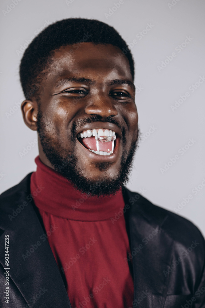 A good adult holds an ice cube with his mouth, namely healthy teeth. A good adult holds an ice cube with his mouth, namely healthy teeth.