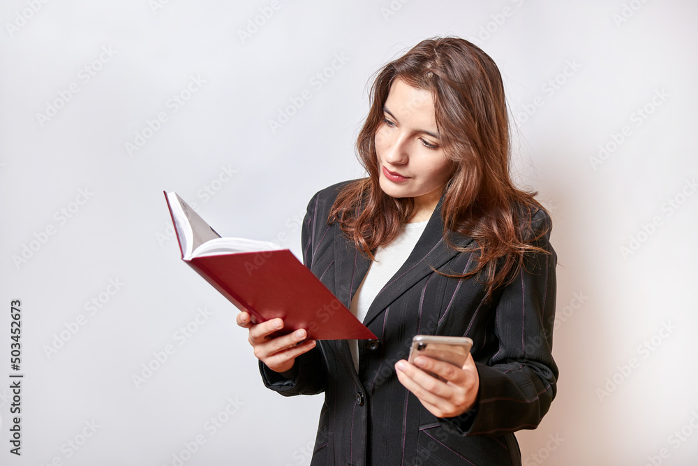 Beautiful businesswoman talking on the phone and looking at notes in a notebook. Beautiful businesswoman talking on the phone and looking at notes in a notebook.