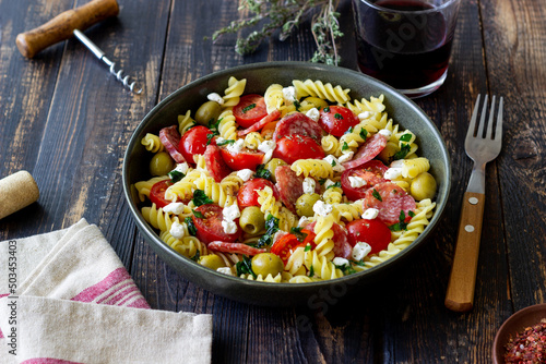 Salad with fusilli pasta, sausage, olives and cottage cheese. Italian food.