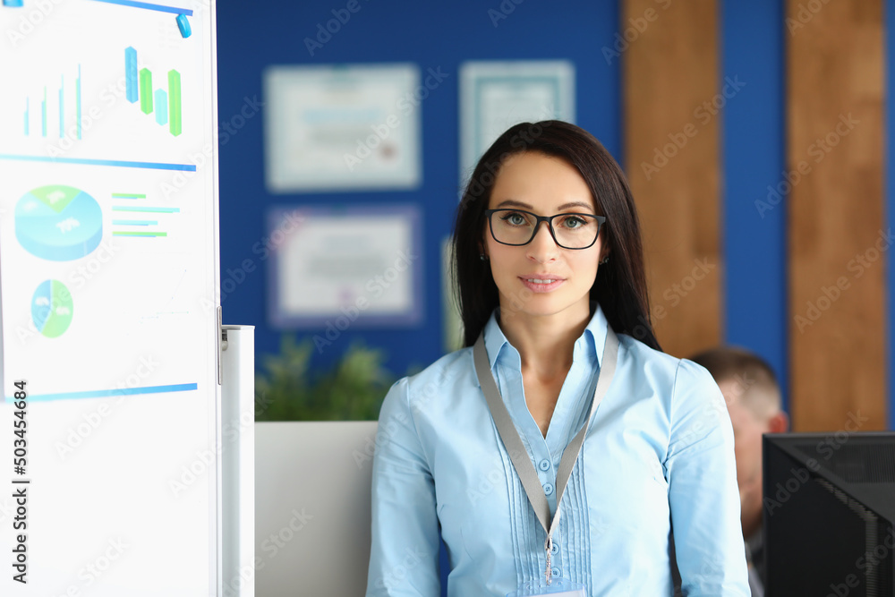 Confident young businesswoman in corporation office, wearing glasses