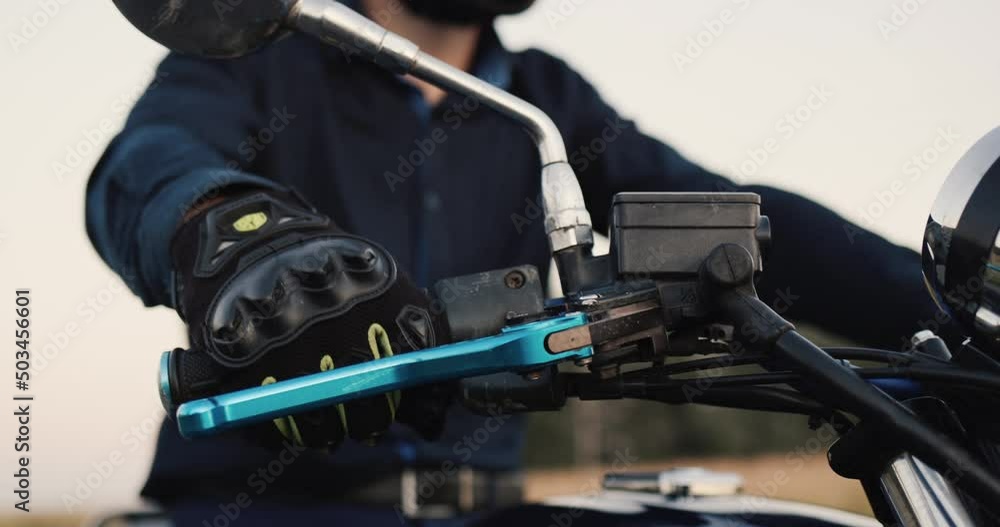 Motorcyclist's hand turns accelerator handle on steering wheel Motorcyclist's hand turns accelerator handle on steering wheel