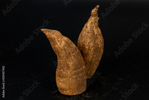 Tapioca / Kappa - roots of the cassava plant, cut and whole isolated in extendable black background shot using studio lights, Isolated, Nobody, Macro, Nutritious, Healthy Food, Roots, tropical food.  photo