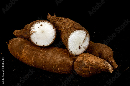 Tapioca / Kappa - roots of the cassava plant, cut and whole isolated in extendable black background shot using studio lights, Isolated, Nobody, Macro, Nutritious, Healthy Food, Roots, tropical food. 