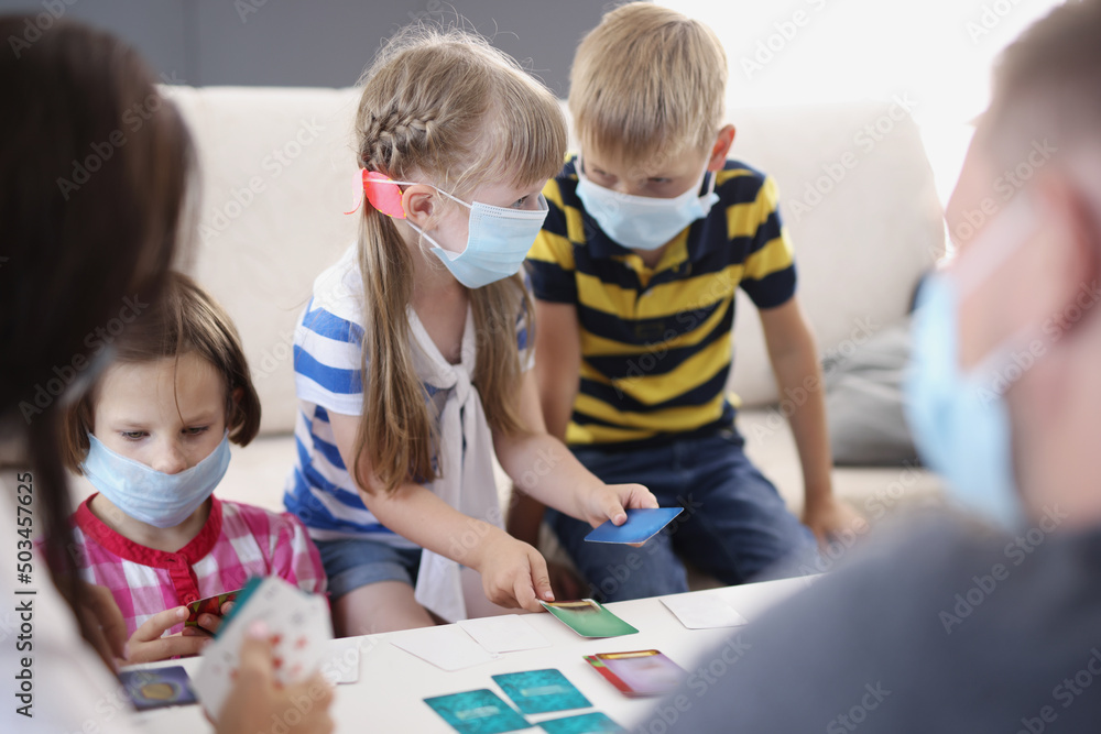 Kids in face masks, prevent virus spread in kindergarten, developing card game Kids in face masks, prevent virus spread in kindergarten, developing card game