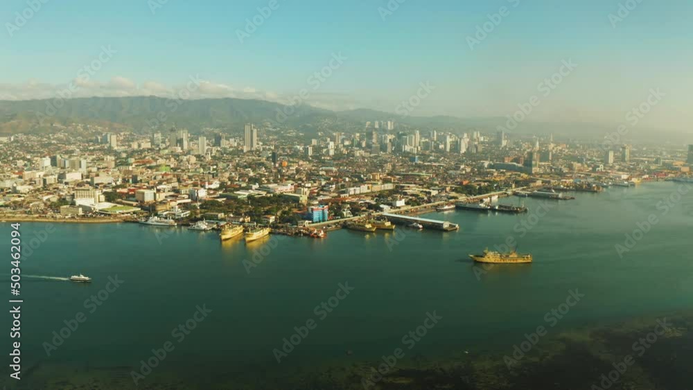 Cityscape: Cebu city with modern buildings, skyscrapers and seaport with ships and ferries, top view during sunrise. Philippines. Cityscape: Cebu city with modern buildings, skyscrapers and seaport with ships and ferries, top view during sunrise. Philippines.