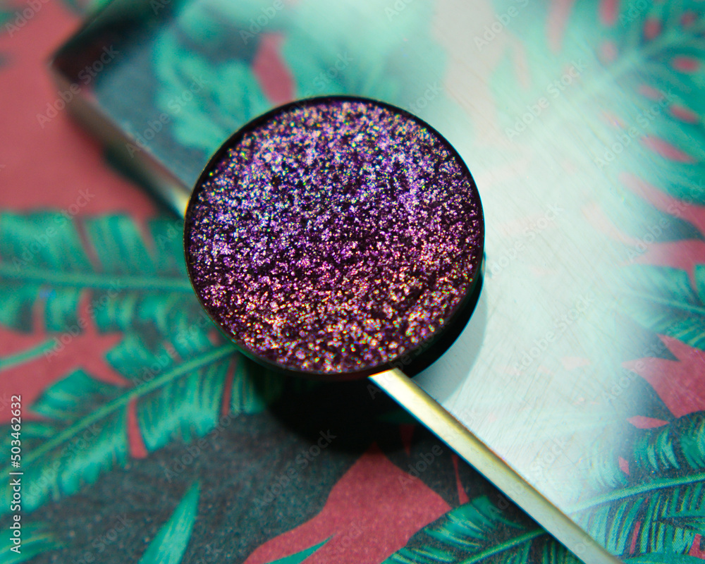 Single glittery violet eye shadow on floral leaf background with acrylic - obrazy, fototapety, plakaty 