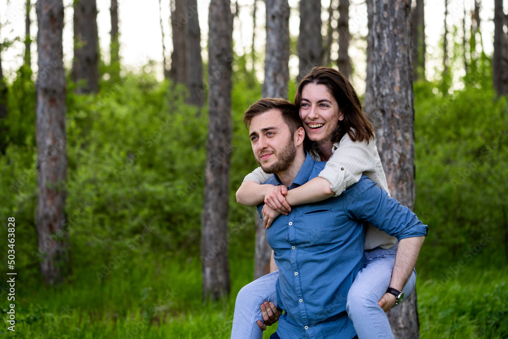 Fototapeta premium Husband giving a piggyback to his wife 