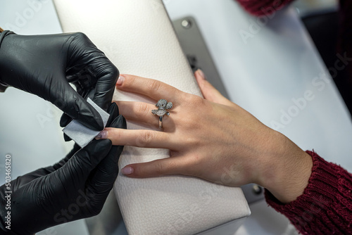 manicurist makes the client preparatory procedures for applying varnish in a beauty salon © RomanR