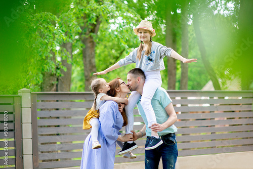 Happy family-mother,father and two children daughters little girl teen having fun outdoor