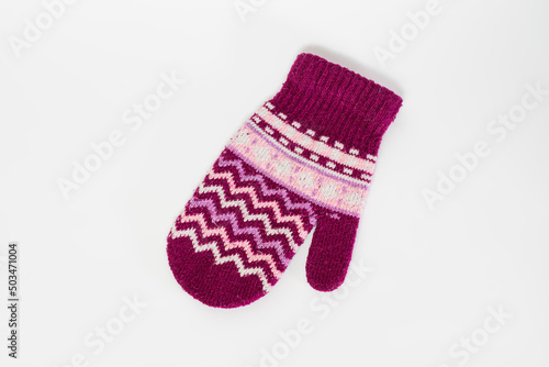 Knitted mitten made of pink wool isolated on a white background.