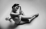 Young gymnast girl stretching and training. Beauty flexible dancer posing in studio