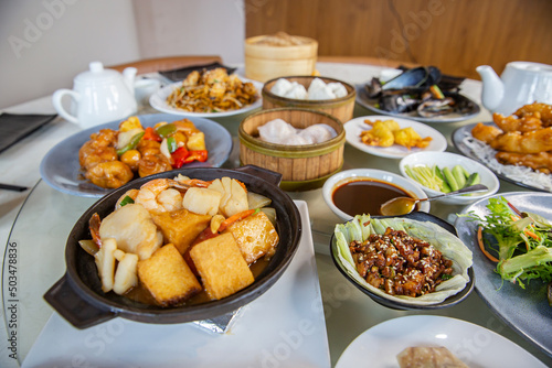 Food platter combo set of traditional Cantonese yum-cha dim sum Asian gourmet cuisine meal food dish on the round table includes dishes of duck, pork, fish, chicken, vegetables, tea, dumplings, buns